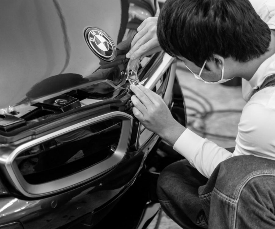Installer applying paint protection film by hand in the shop bay